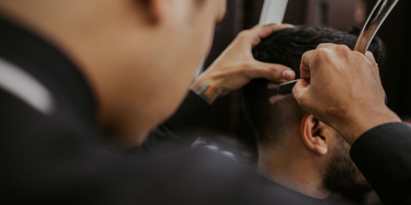 A man getting his hair cut at a Turkish barbers near me