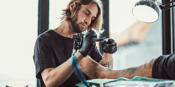 A man giving someone a tattoo near me