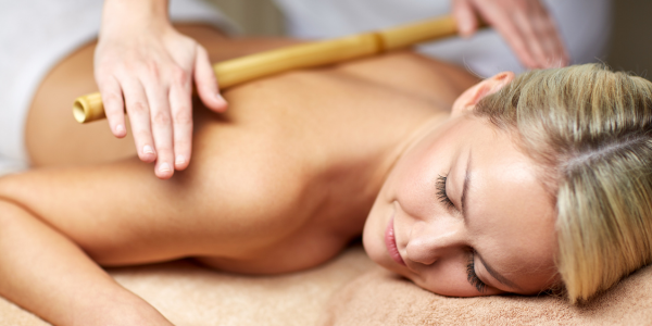A woman getting a sports massage near me with a bamboo cane