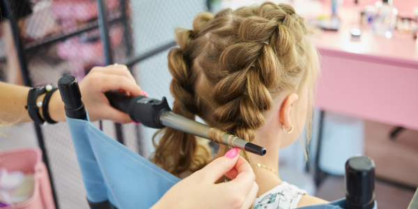 A girl getting her hair braided at a hairdressers near me